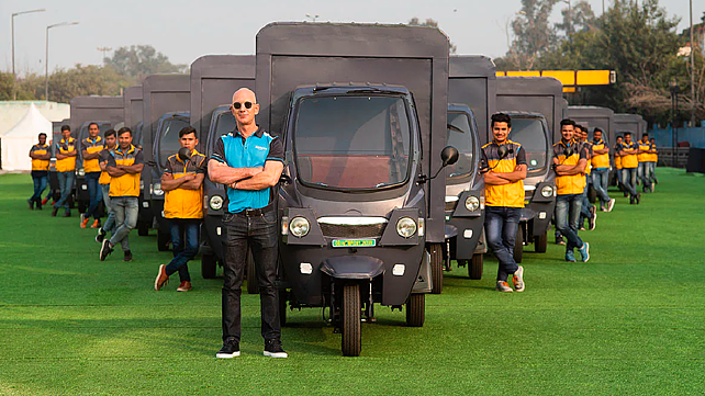 File Photos - Jeff Bezos standing with electric three-wheelers.