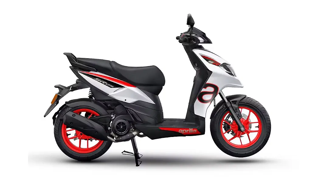 Glossy Tech White Aprilia SR 175 scooter parked on a vibrant city street, showcasing its sleek, angular design.