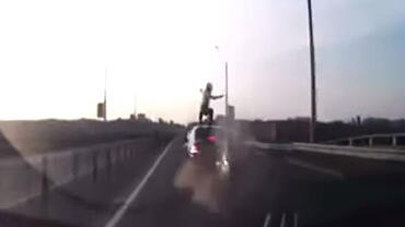 Motorcycle rider crashes into car and lands safely on his feet like a boss